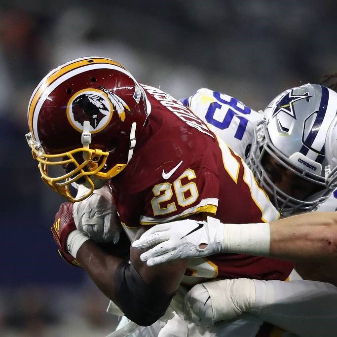 Adrian Peterson, camisa 26 do Washington Redskins, corre com a bola e fura a marcação do Dallas Cowboys